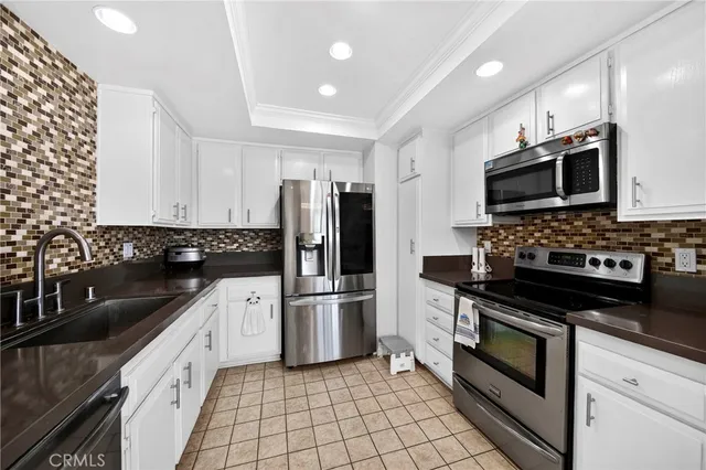 a kitchen with granite countertop a sink stove and refrigerator