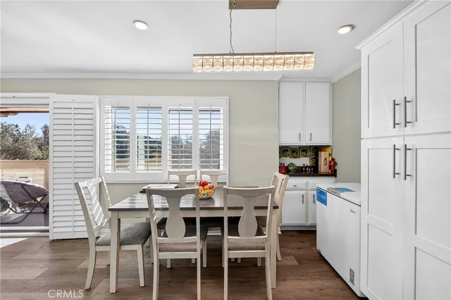 a kitchen with a dining table chairs and white appliances