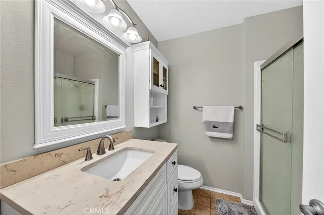 a bathroom with a granite countertop sink a toilet and mirror