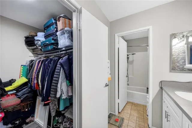 a view of walk in closet with clothes and shoes