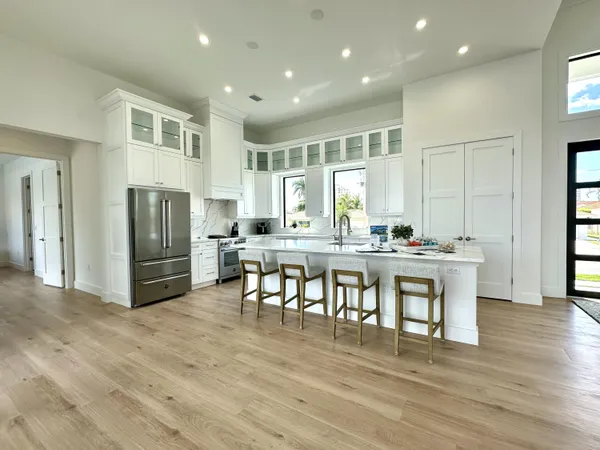 a dining hall with stainless steel appliances granite countertop a refrigerator and a stove