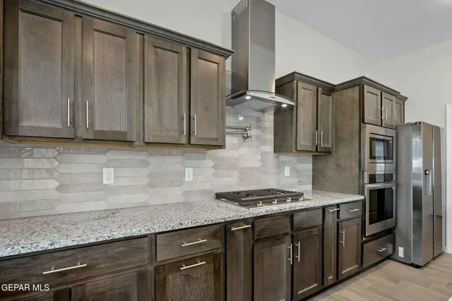 a kitchen with stainless steel appliances granite countertop a sink stove and refrigerator