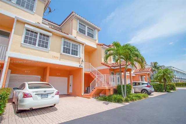 a view of a street with a building and couple of cars parked in front of it