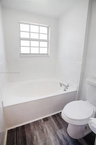 a view of a room with a ceiling fan and window