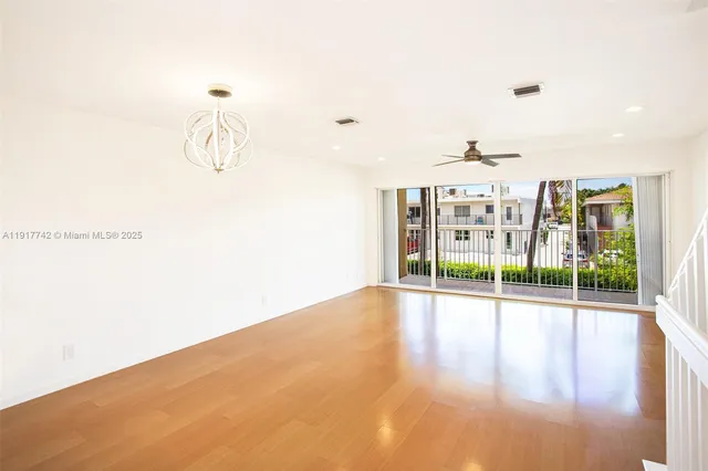 a kitchen with a refrigerator a sink and wooden floor