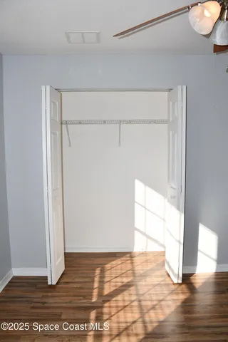 a view of empty room with wooden floor