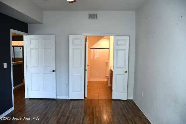 a view of empty room with wooden floor and closet