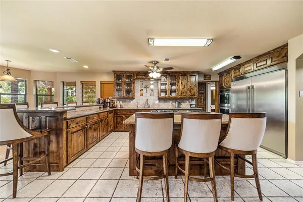 a kitchen with stainless steel appliances granite countertop a kitchen island a table and chairs