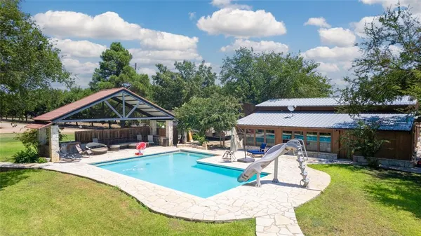 a view of a house with swimming pool and sitting area