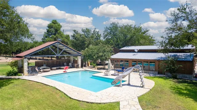a view of a house with swimming pool and sitting area