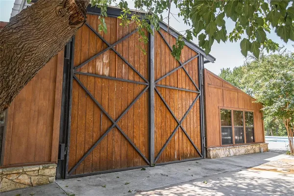 a view of a patio with table and chairs under an umbrella next to a yard
