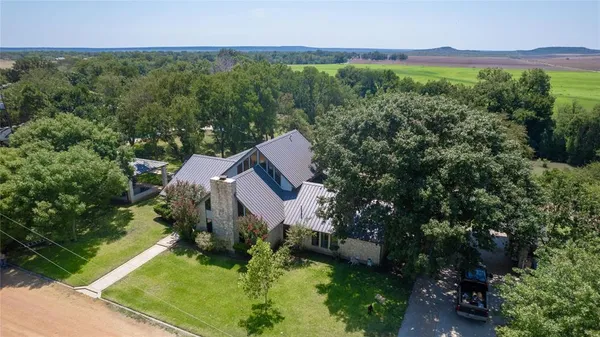 a aerial view of a house with a yard and a large pool