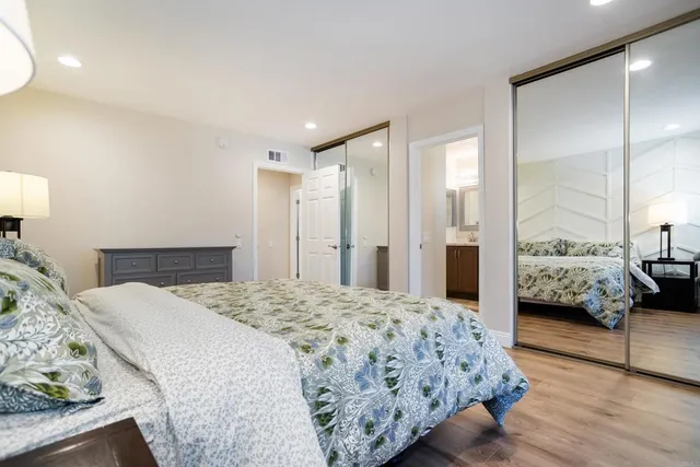 a bedroom with a bed and a large mirror