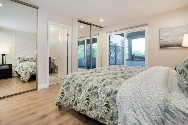 a spacious bedroom with a large bed and wooden floor