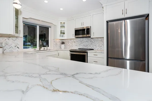 a kitchen with stainless steel appliances a refrigerator sink and microwave
