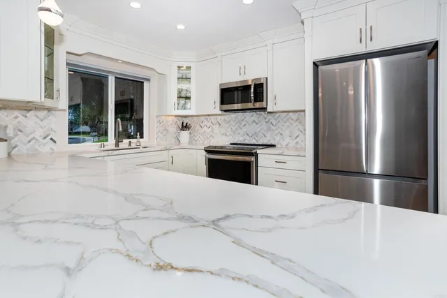 a kitchen with stainless steel appliances a refrigerator sink and microwave