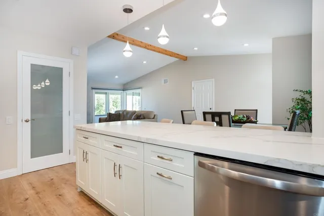 a kitchen with kitchen island a sink and white cabinets