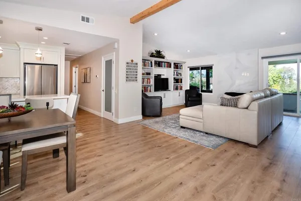 a living room with furniture and a wooden floor