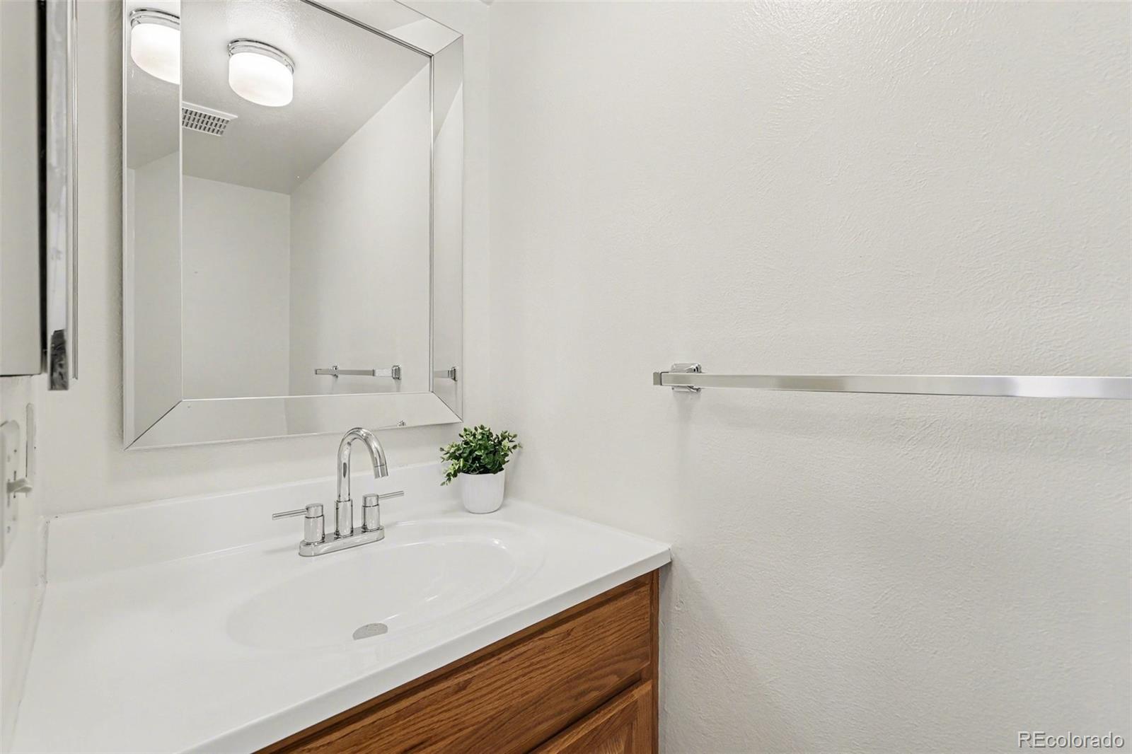 15922 East Rice Place, Unit B Aurora, CO 80015 - Photo 11 of 30 a bathroom with a sink and a mirror
