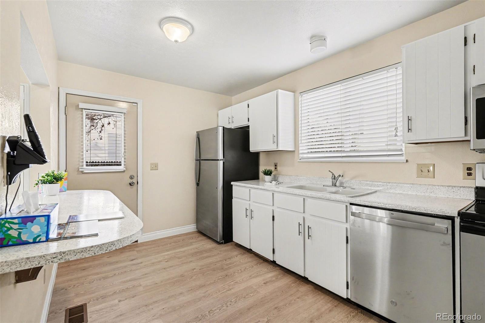 15922 East Rice Place, Unit B Aurora, CO 80015 - Photo 8 of 30 a kitchen with stainless steel appliances granite countertop a sink stove and refrigerator