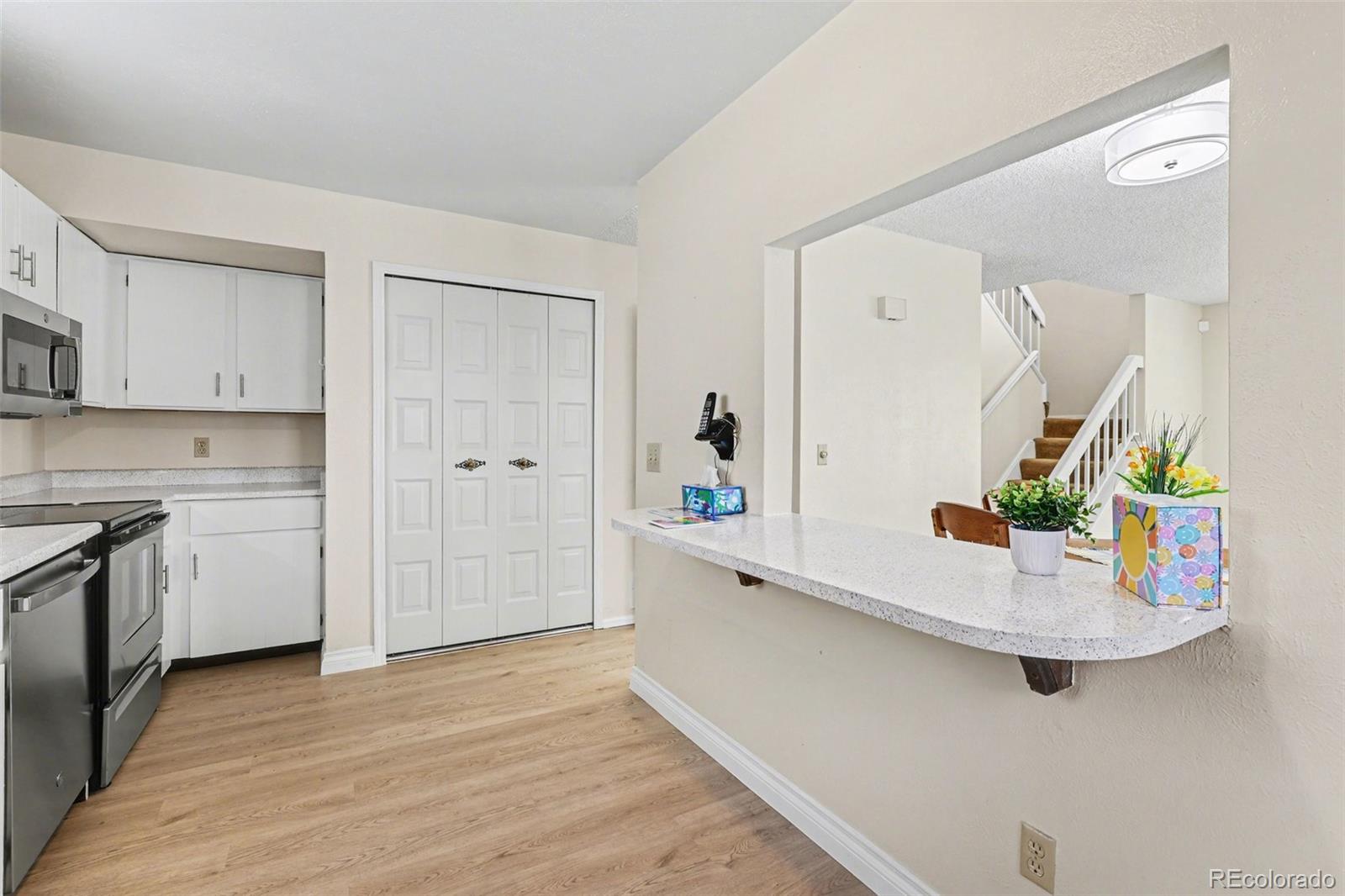 15922 East Rice Place, Unit B Aurora, CO 80015 - Photo 10 of 30 a kitchen with stainless steel appliances granite countertop a white cabinets and sink