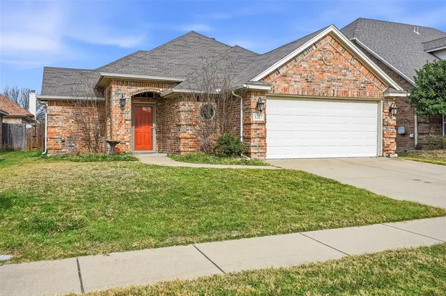 a view of a house with a small yard and a garage