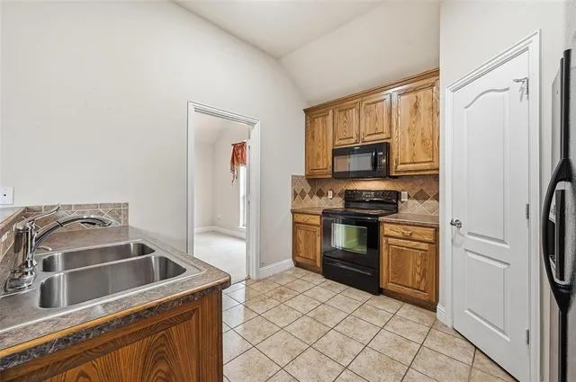 a kitchen with a refrigerator sink and stove top oven