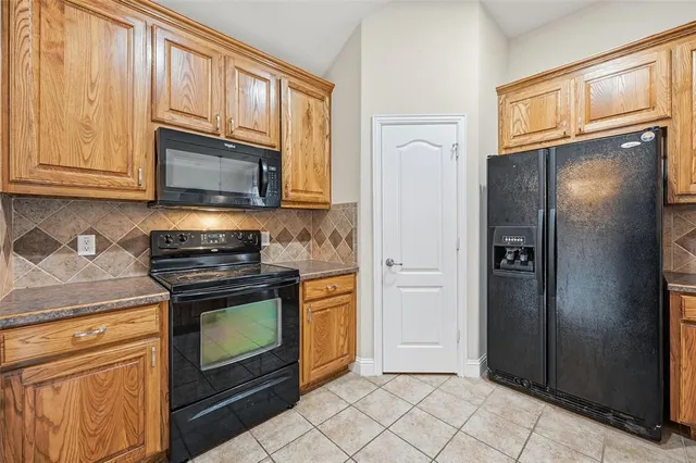 a kitchen with granite countertop a refrigerator stove and microwave