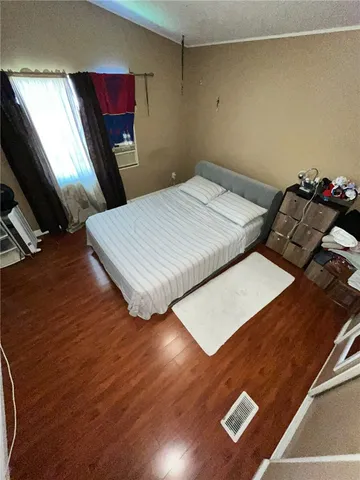 a bedroom with a bed window and a flat screen tv