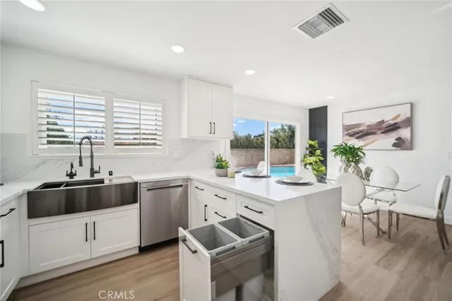 a kitchen with cabinets appliances a sink and a window