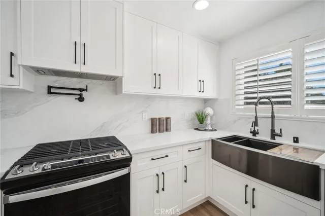 a kitchen with white cabinets and stainless steel appliances