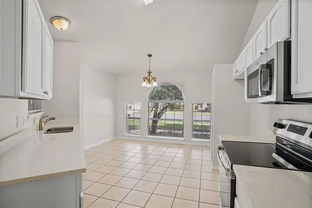 a kitchen with granite countertop a stove a sink and a cabinets