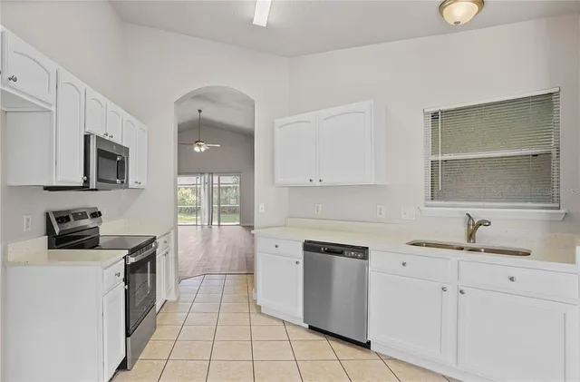 a kitchen with a sink a stove and cabinets