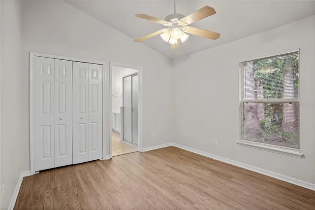 an empty room with a window and a fan