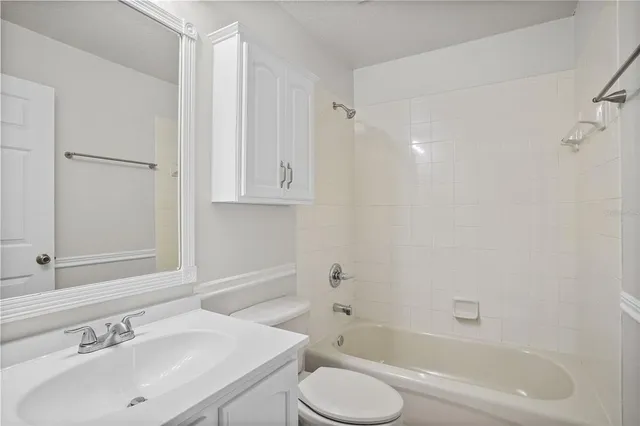 an empty room with windows and chandelier fan