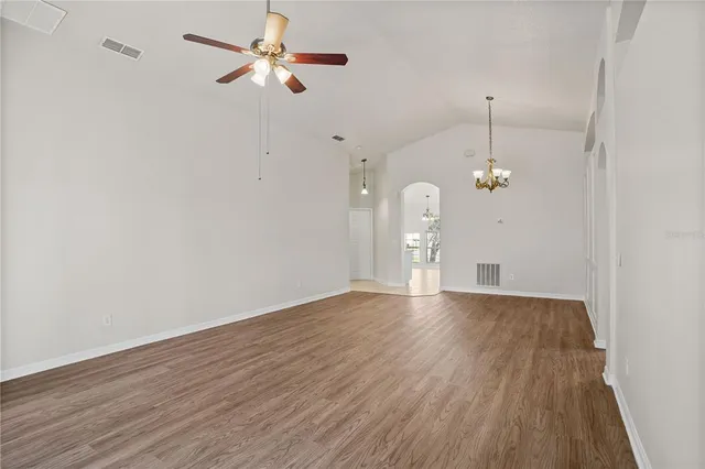 a view of empty room with wooden floor and ceiling fan
