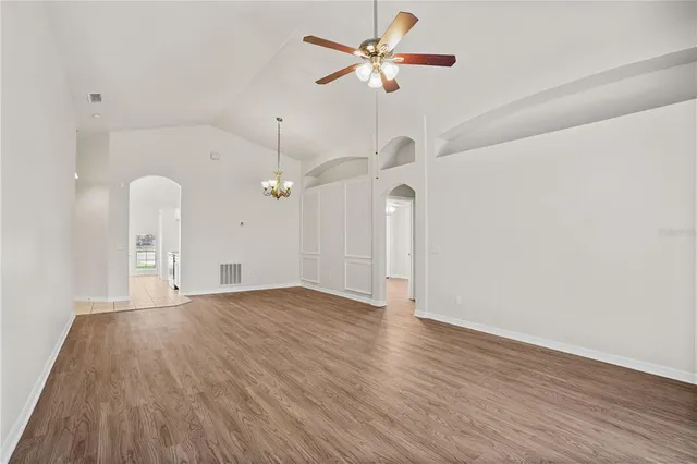 a view of a room with wooden floor and a ceiling fan