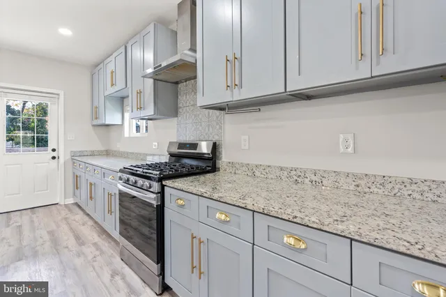 a kitchen with stainless steel appliances granite countertop a sink stove and cabinets