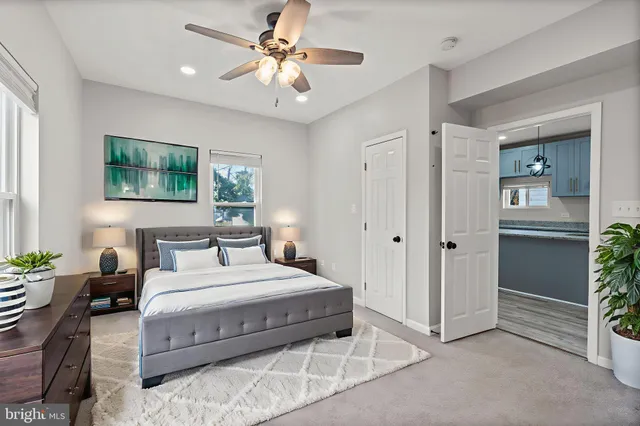 a bedroom with a large bed a chandelier and windows