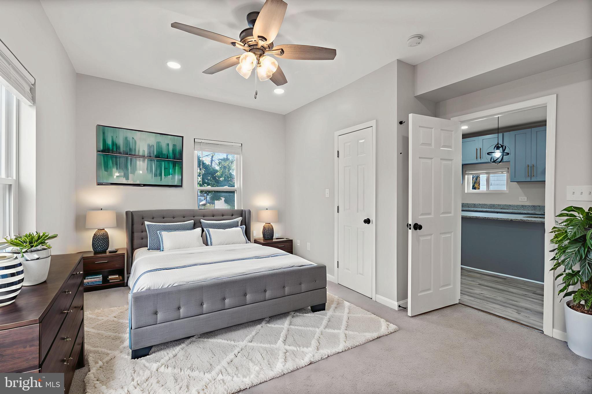 3809 West Cold Spring Lane Baltimore, MD 21215 - Photo 24 of 47 a bedroom with a large bed a chandelier and windows