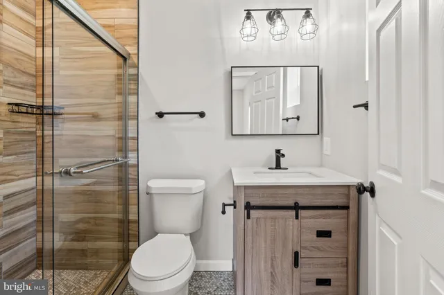 a bathroom with a granite countertop toilet sink and mirror
