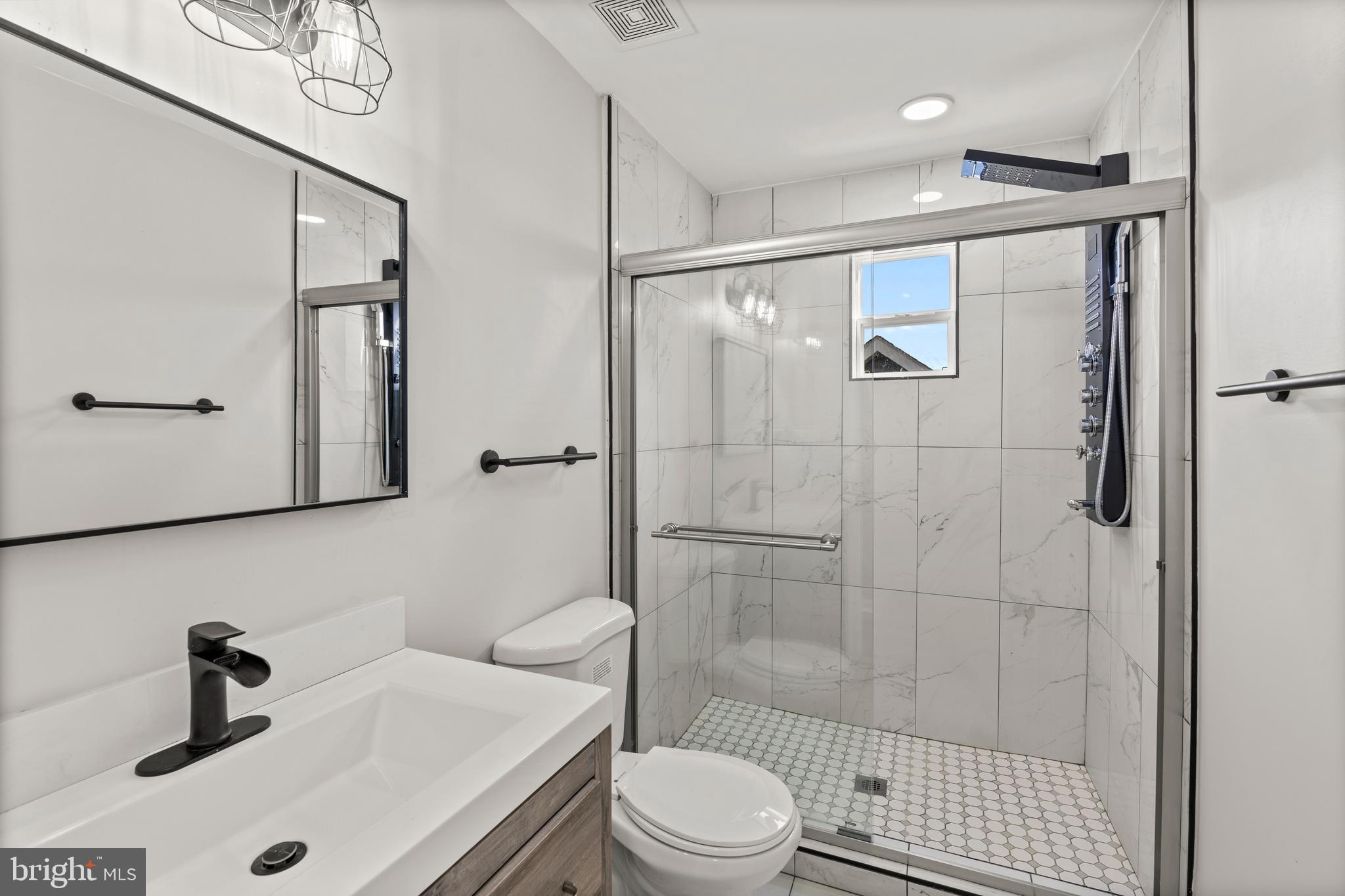 3809 West Cold Spring Lane Baltimore, MD 21215 - Photo 30 of 47 a bathroom with a sink a toilet and shower