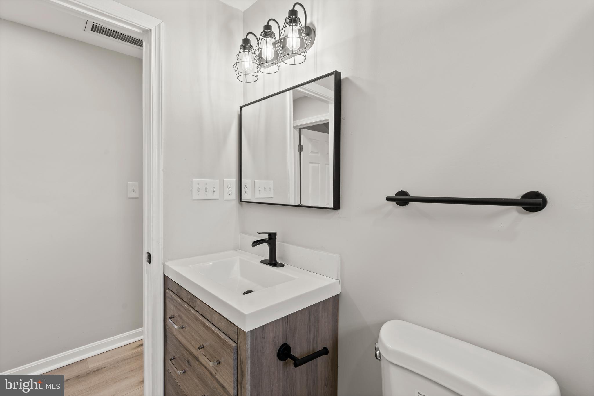 3809 West Cold Spring Lane Baltimore, MD 21215 - Photo 32 of 47 a bathroom with a sink a toilet and mirror