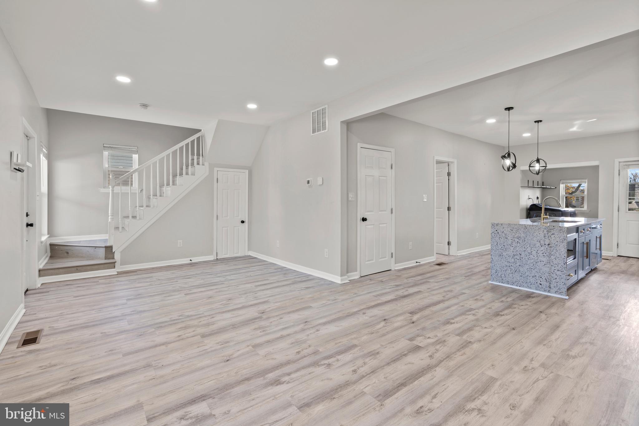 3809 West Cold Spring Lane Baltimore, MD 21215 - Photo 10 of 47 a view of an empty room with wooden floor and a kitchen