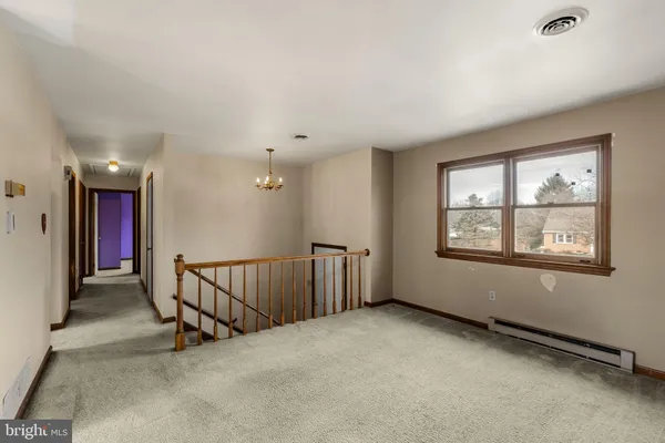 a view of an empty room with windows & cabinet