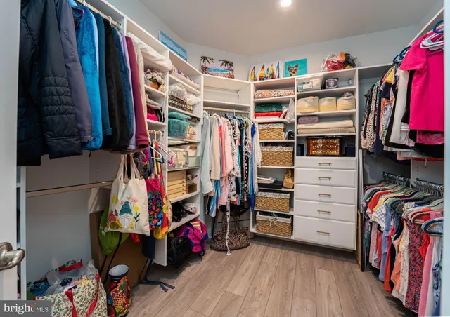 a view of walk in closet with clothes and shoes
