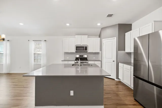 a kitchen with a refrigerator a stove a microwave and cabinets