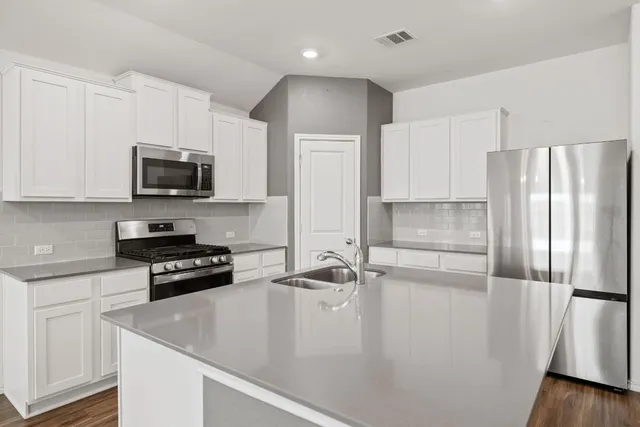 a kitchen with stainless steel appliances a refrigerator stove and sink