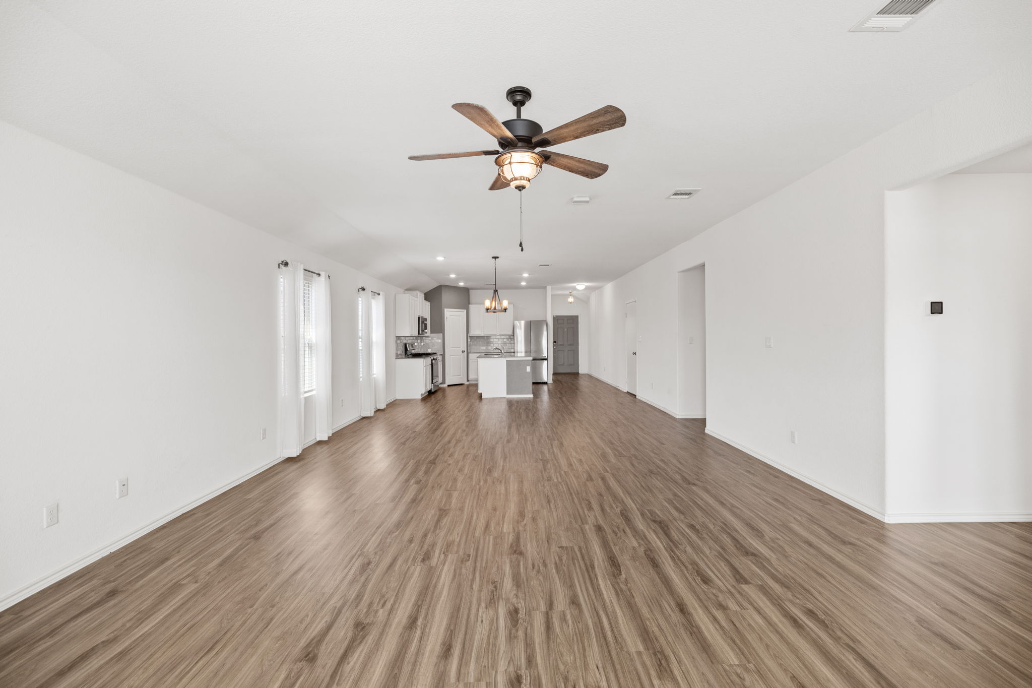 127 George Kimble Cove Bastrop, TX 78602 - Photo 20 of 40 Unfurnished living room featuring dark wood-style flooring and ceiling fan