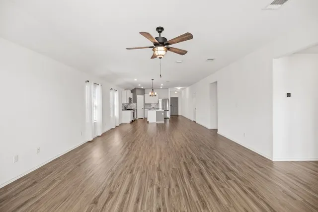 a view of a livingroom with a hardwood floor and a ceiling fan